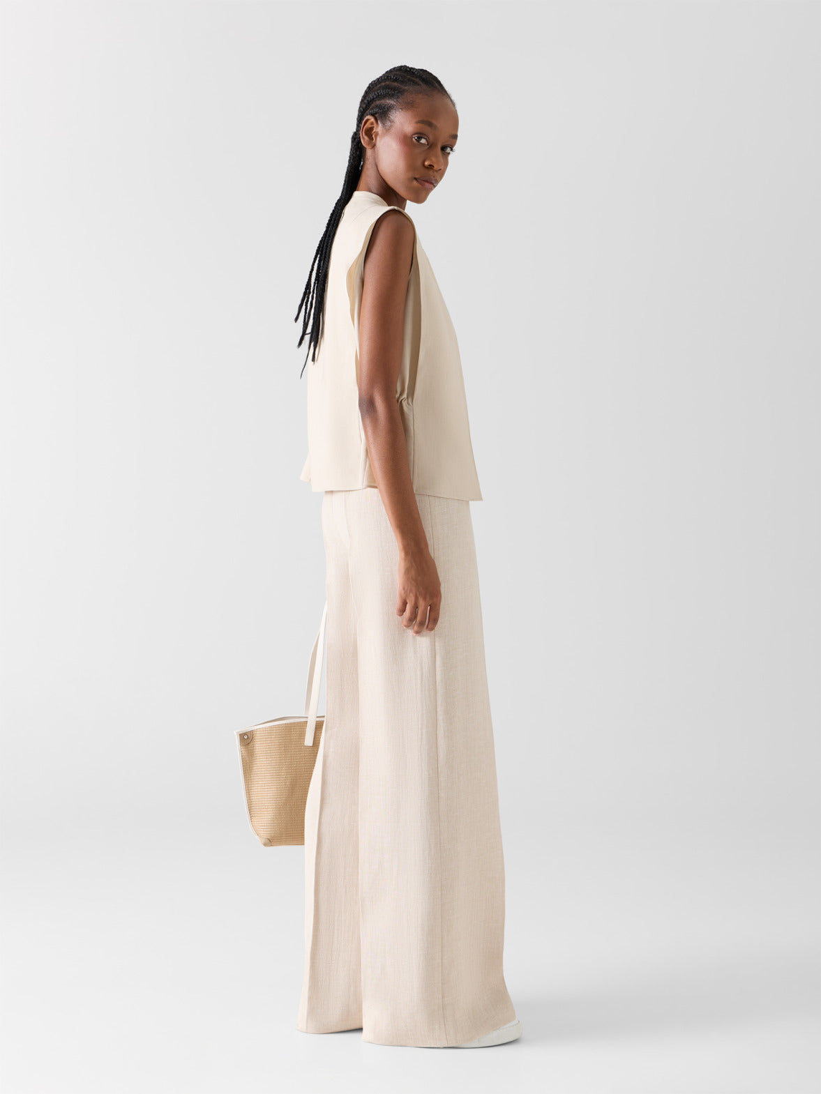 Minimalist Akris Spring/Summer ensemble featuring wide-leg linen trousers and a sleeveless cream top. The look emphasizes natural textures, fluid tailoring, and a sophisticated monochromatic aesthetic.