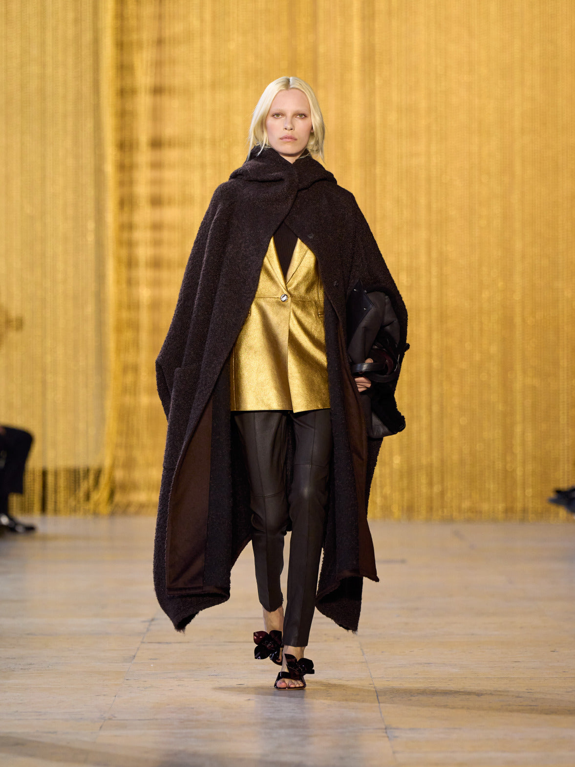 A tribute to Olga de Amaral in the Akris FW26 collection in Paris, defined by a dialogue between deep blacks, burgundy, and metallic gold accents