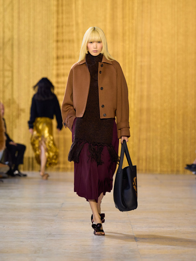 A tribute to Olga de Amaral in the Akris FW26 collection in Paris, defined by a dialogue between deep blacks, burgundy, and metallic gold accents