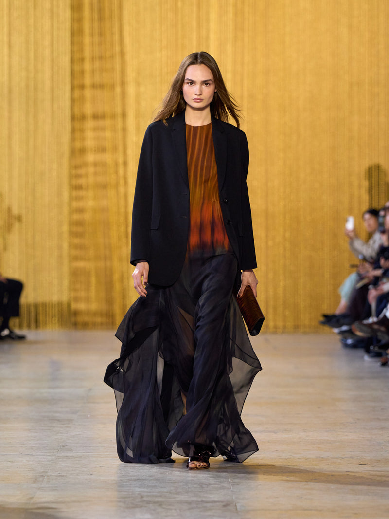 A tribute to Olga de Amaral in the Akris FW26 collection in Paris, defined by a dialogue between deep blacks, burgundy, and metallic gold accents