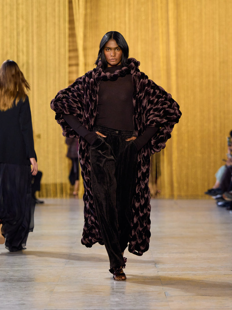 A tribute to Olga de Amaral in the Akris FW26 collection in Paris, defined by a dialogue between deep blacks, burgundy, and metallic gold accents