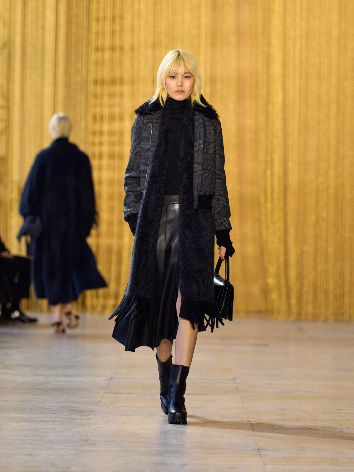 A tribute to Olga de Amaral in the Akris FW26 collection in Paris, defined by a dialogue between deep blacks, burgundy, and metallic gold accents