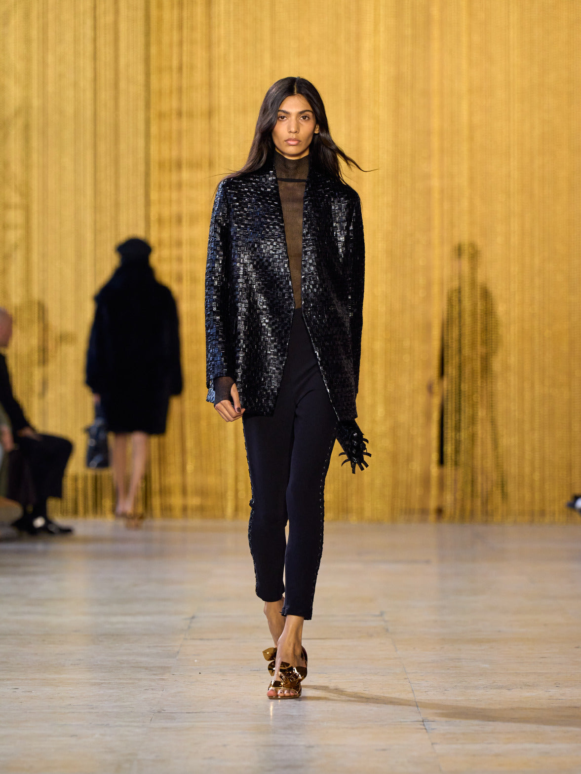 A tribute to Olga de Amaral in the Akris FW26 collection in Paris, defined by a dialogue between deep blacks, burgundy, and metallic gold accents