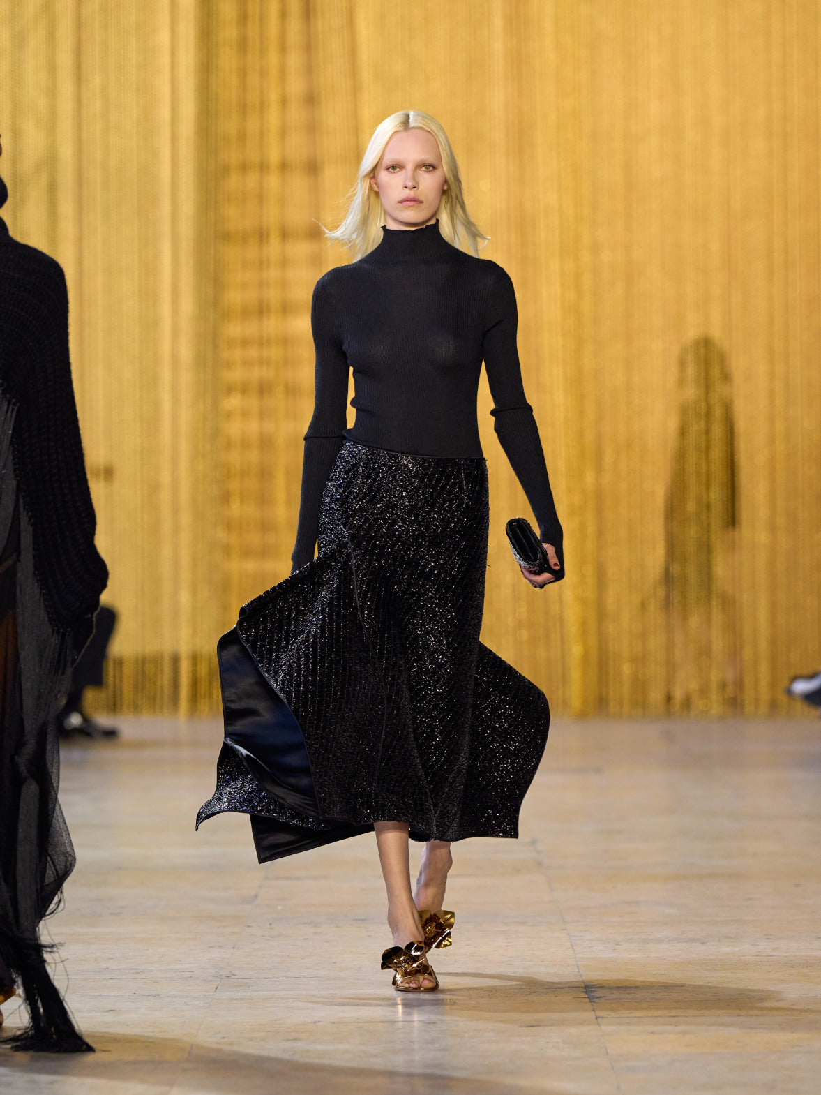 A tribute to Olga de Amaral in the Akris FW26 collection in Paris, defined by a dialogue between deep blacks, burgundy, and metallic gold accents