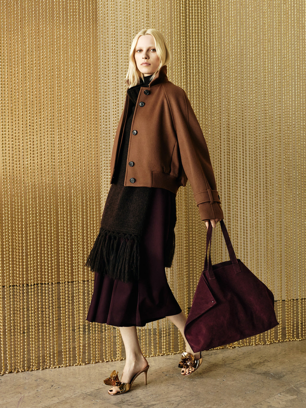 Look from the Akris Fall 2026 collection featuring elevated knitwear, refined outerwear, and the iconic Ai handbag in seasonal burgundy tones.