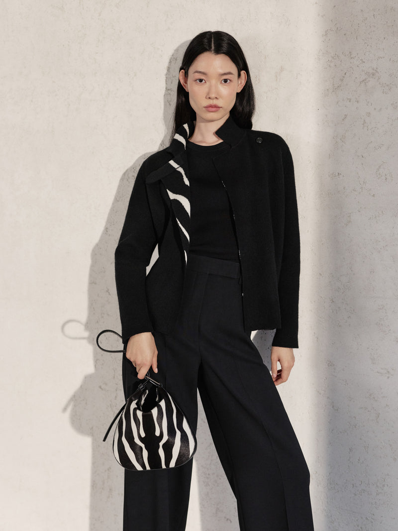 Discover the sophisticated versatility of the Akris Pre-Fall collection, featuring a tailored black ensemble with a subtle zebra-accented collar. Complete the look with the graphic elegance of the Anna Hobo handbag in a matching zebra print. Experience the perfect harmony of modern design and Swiss craftsmanship.