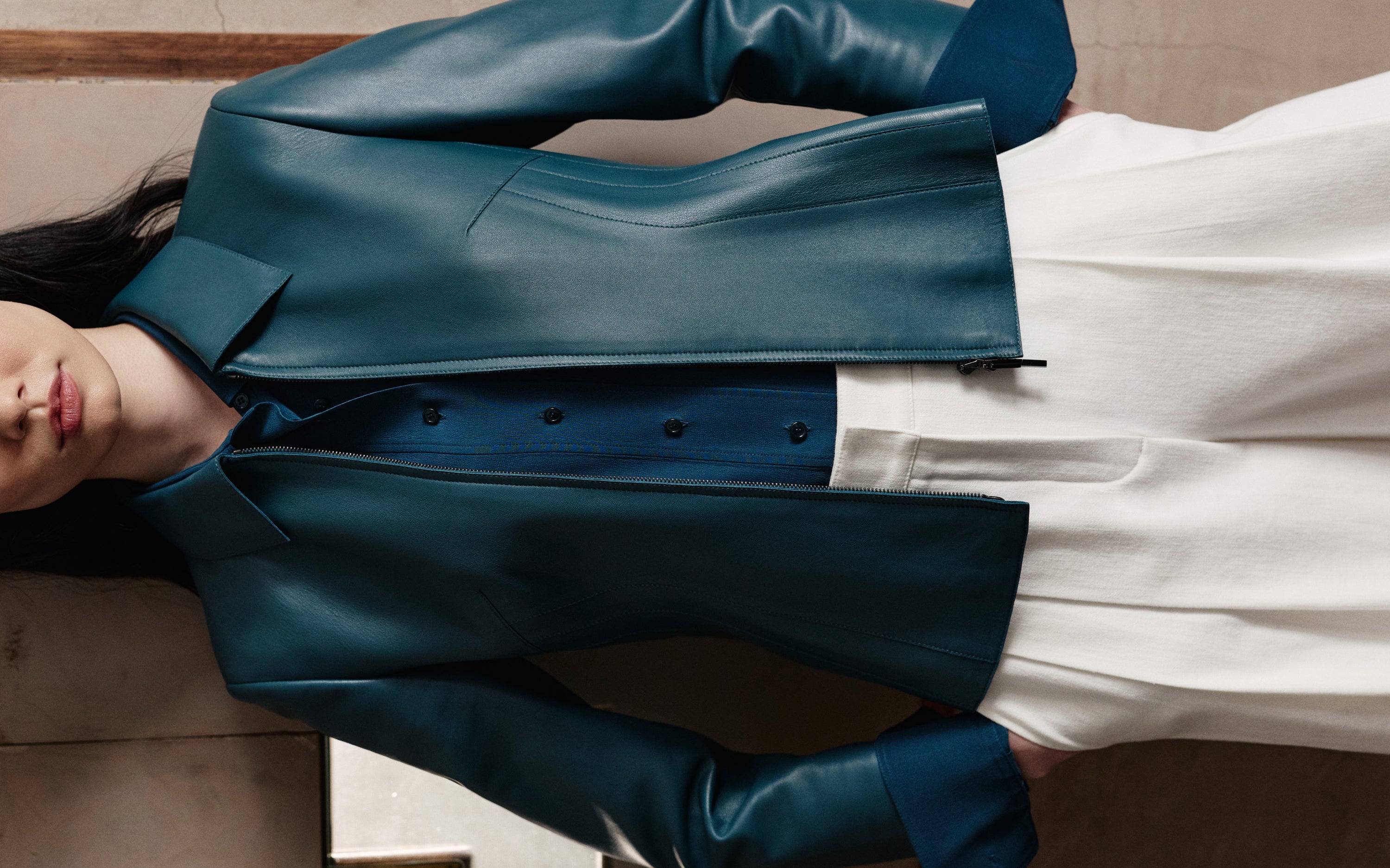Discover the sophisticated tailoring of the Akris Pre-Fall collection, showcasing a luxury leather jacket in a rich ottanio blue hue. Paired with elegant, high-waisted white trousers, this ensemble offers a modern take on color-blocking. Elevate your seasonal wardrobe with fluid lines and exceptional Swiss craftsmanship.