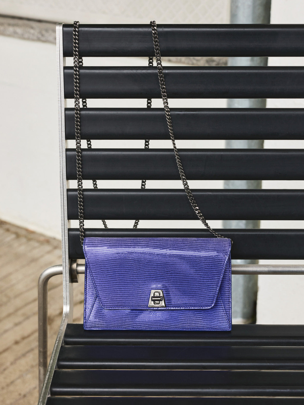 Akris Pre-Fall 2026 collection luxury purple shoulder bag.
Elegant lizard-effect embossed leather purse with a metallic chain strap.
Features a sleek envelope silhouette and a secure silver turn-lock clasp.
