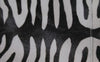 Zebra print coat paired with white mules from the Akris Pre-Fall 2026 collection styled in a modern interior. High-end luxury fashion featuring bold animal patterns and fluid silhouettes.