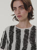 Discover the artistic energy of the Akris punto Spring collection, celebrating playful movement and the vibrant scribble print. From colorful patterned skirts and jumpsuits to bold black-and-white graphic coordinates and striking orange totes, these pieces bring creative expression to life. Experience joyful, modern luxury and exquisite Swiss design.